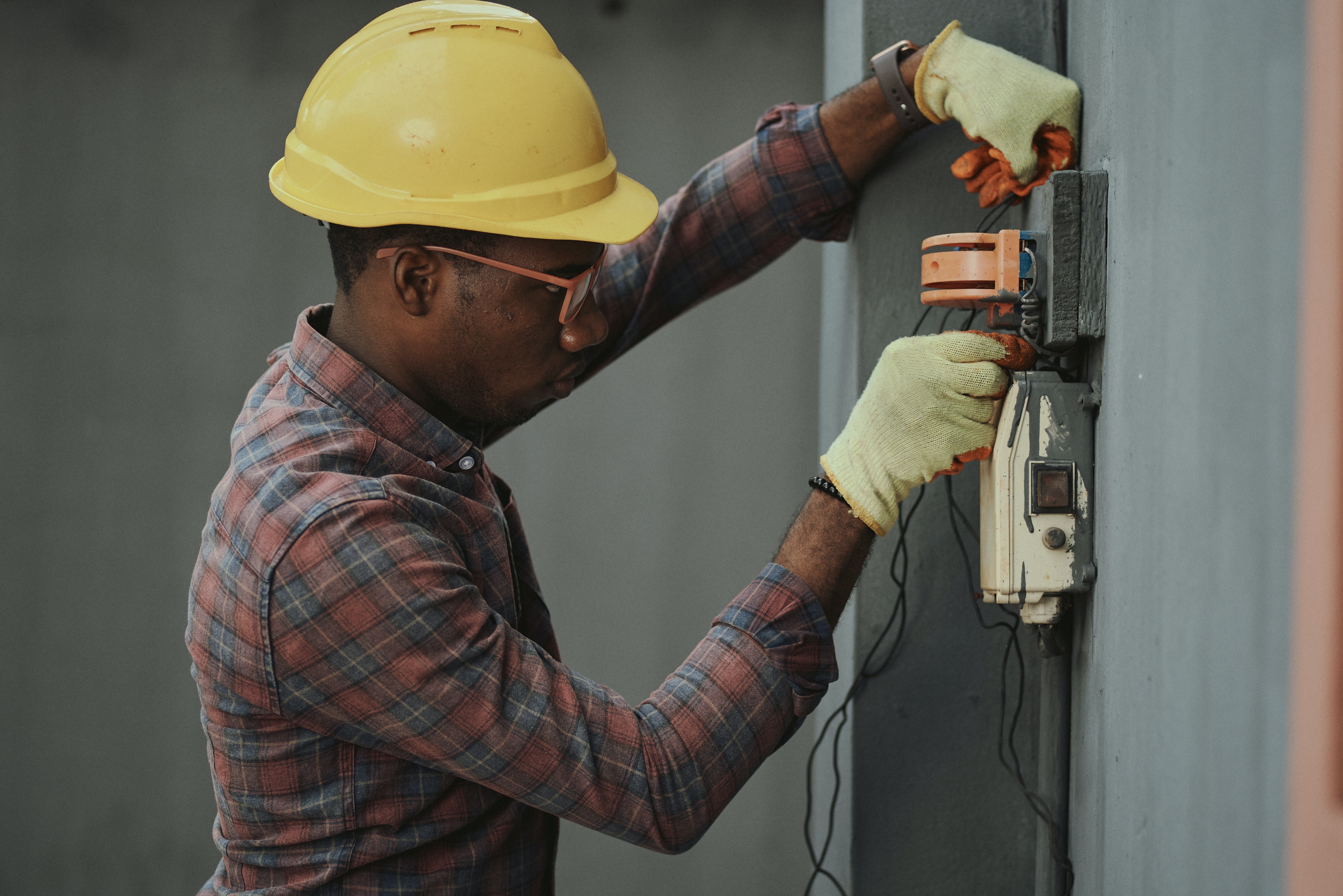 An electrician working on wires on a panel
