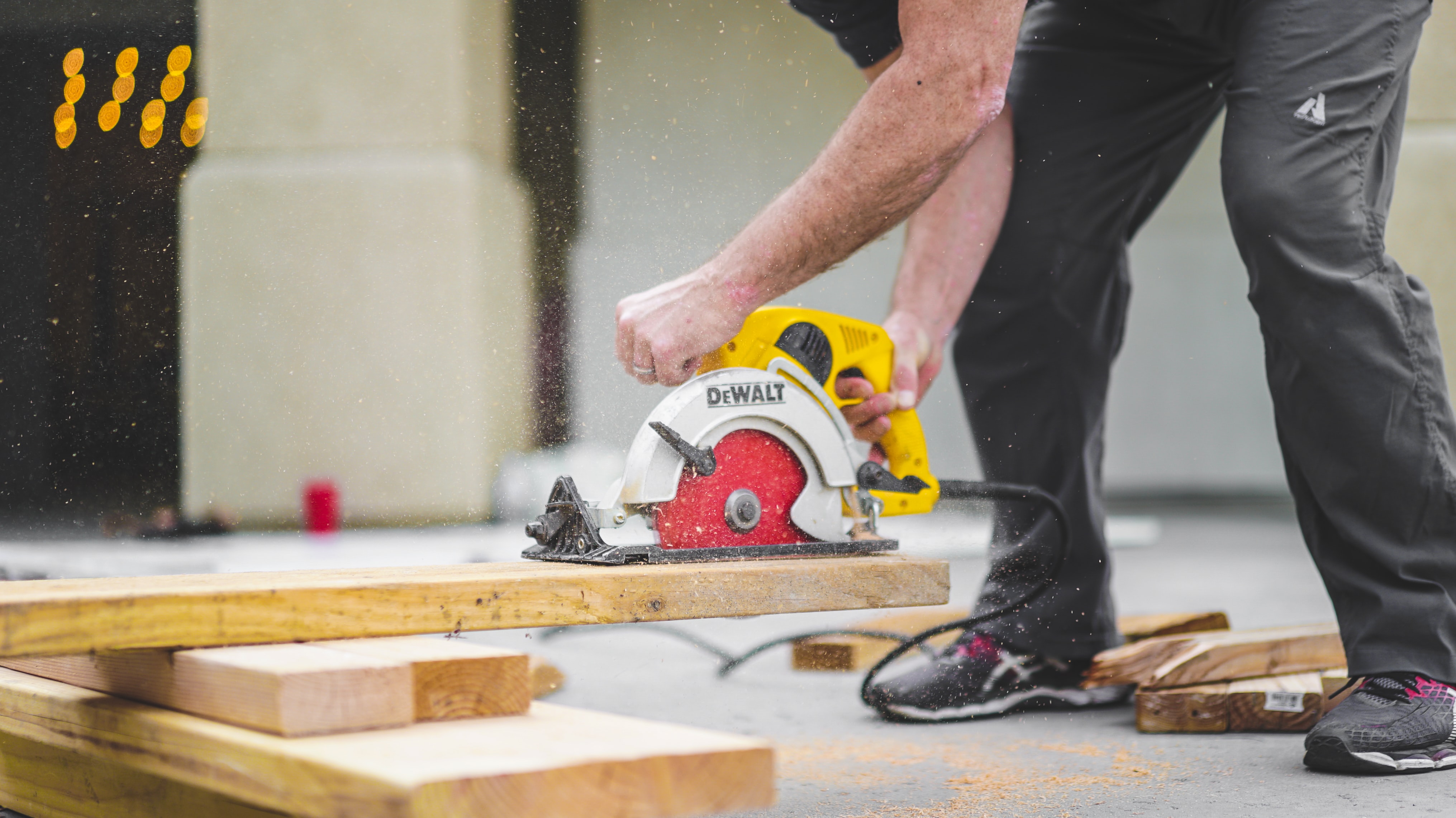 A carpenter cutting a piece of lumber with a circular saw